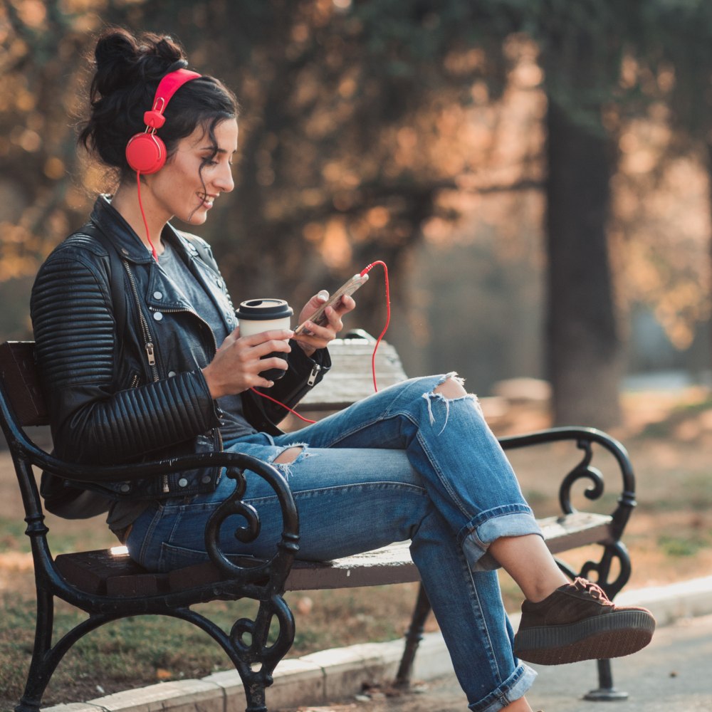 woman in headphones sitting in a park