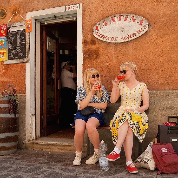 women having a drink in front of a local bar