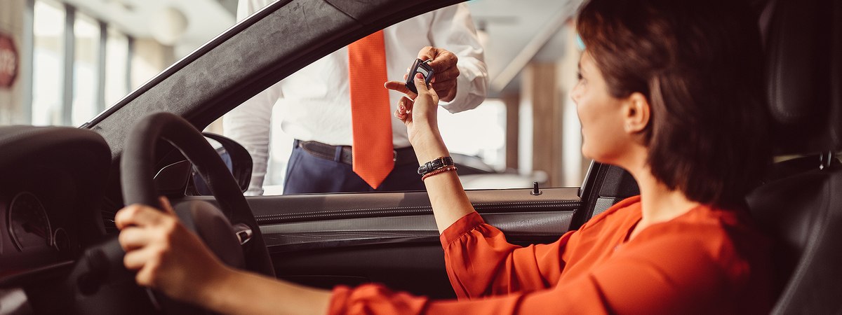 Automotive Sector Cover Photo featuring a woman being handed key for her new car